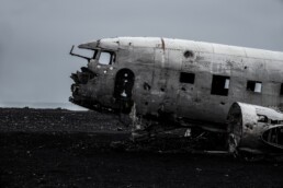 white and black airplane on black sand during daytime